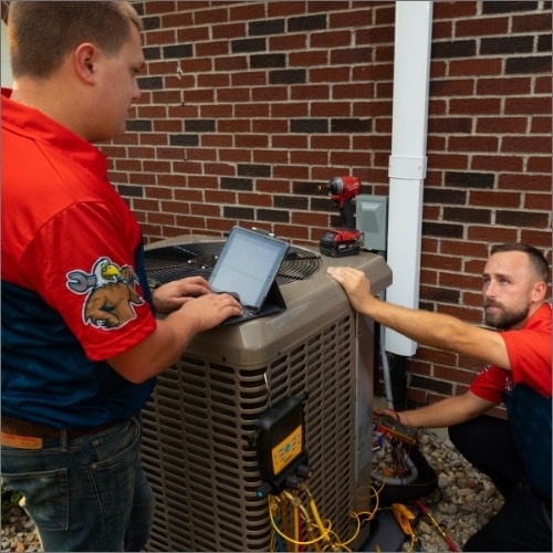 HVAC workers working on a unit