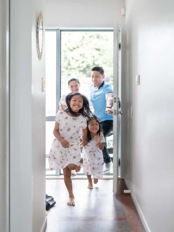 two little girls wearing matching dresses running into house